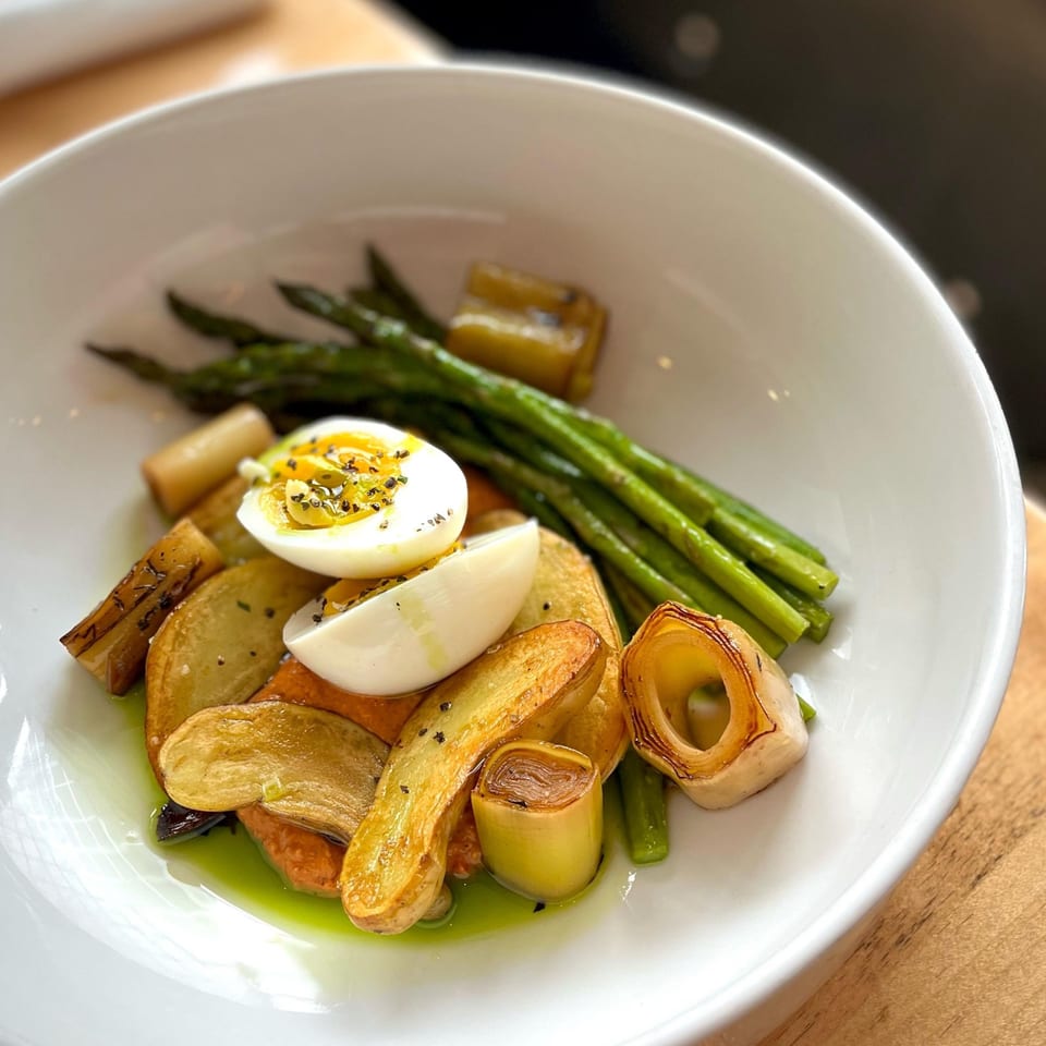 Redcrest Kitchen's American dish with asparagus, roasted potatoes, leeks, and a halved hard-boiled egg.